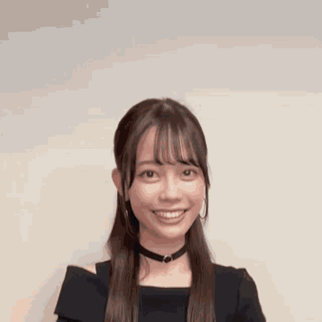 a young woman wearing a choker and earrings is smiling with her arms outstretched