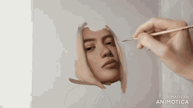 a person is painting a woman 's face with a brush and the words made in animotica are on the bottom
