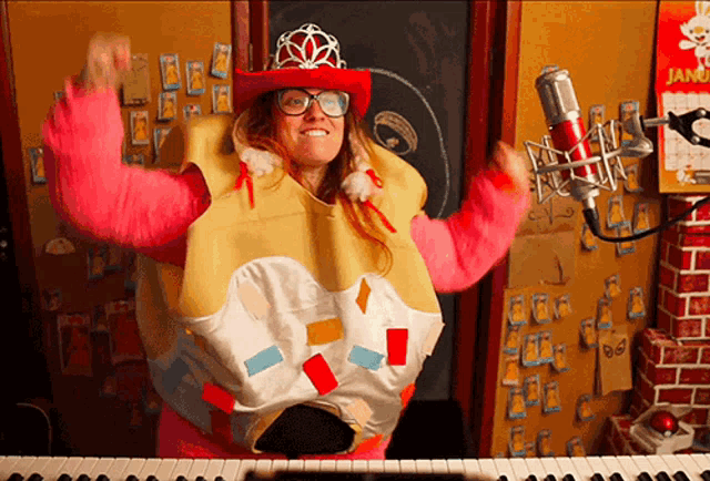 a woman in a costume is standing in front of a piano and a microphone