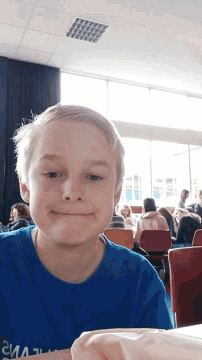 a young boy wearing a blue shirt that says climax