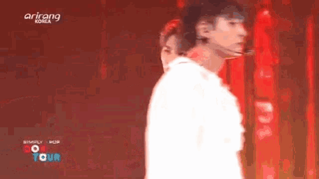 a group of people are dancing on a stage in front of a red background .
