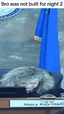 a woman is sitting at a desk with a sign that says mary key on it