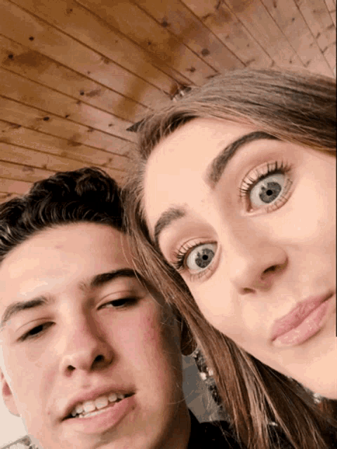 a man and a woman are posing for a picture and the woman has a surprised look on her face
