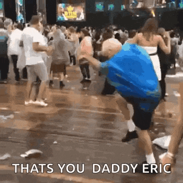 a man in a blue shirt is dancing in front of a crowd at a concert .