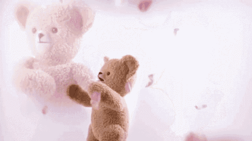 a teddy bear is standing in front of a pink background with petals falling from the sky .