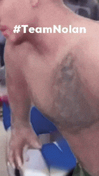 a shirtless man with a tattoo on his chest has the hashtag #teamnolan on his face