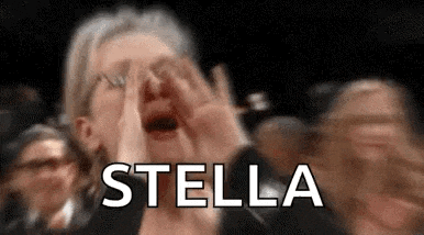 a woman is screaming in a crowd of people while holding her hands to her face and the word stella is visible .