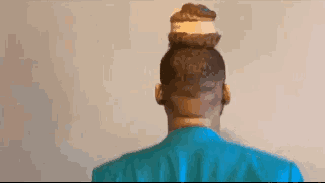 the back of a man 's head with a bun on it