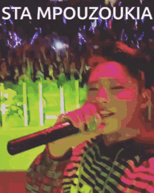 a woman singing into a microphone with the words sta mpouzoukia written above her