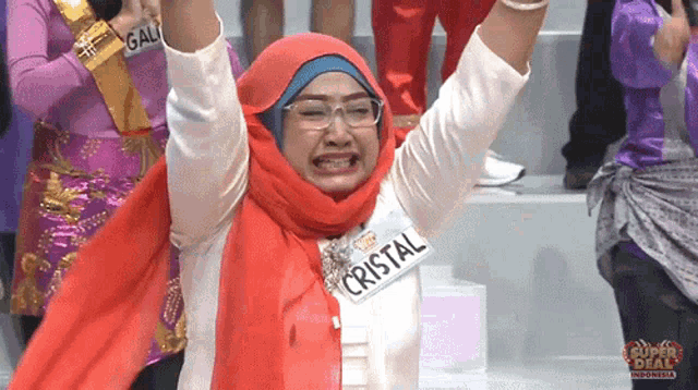 a woman with a name tag that says cristal is raising her arms in the air