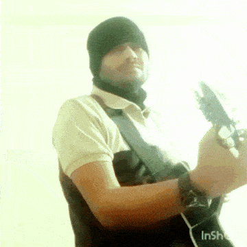 a man playing a guitar with the word inshot in the lower right corner