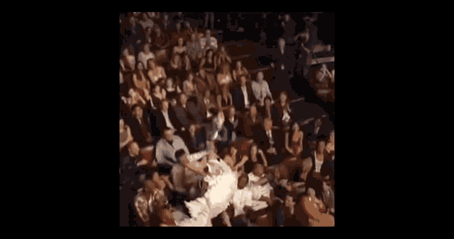 a woman is laying on her back in front of a crowd .