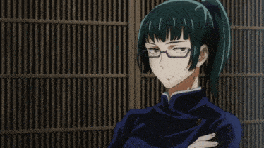 a girl with glasses and a ponytail smiles in front of a fence