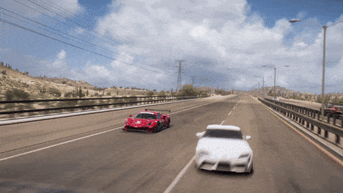 a red sports car and a white sports car are racing down a highway