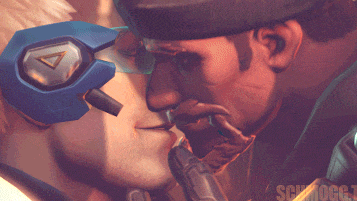 a close up of a man kissing another man with a triangle on his helmet in the background