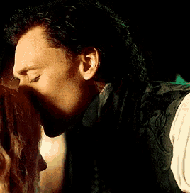 a man is kissing a woman on the cheek