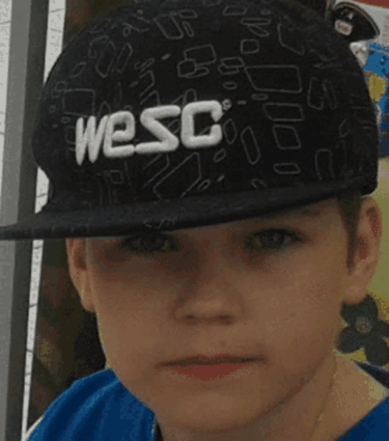 a boy wearing a black hat that says wesc