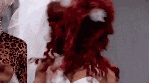 a woman with red hair is wearing a white dress and leopard print shirt .