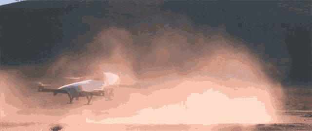 a plane is taking off from a dirt runway