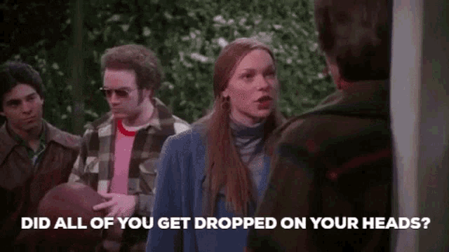 a group of people are standing next to each other and a woman is talking to a man .
