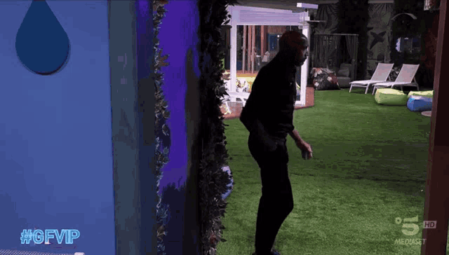 a man is walking in a room with the words #gfvip written on the bottom