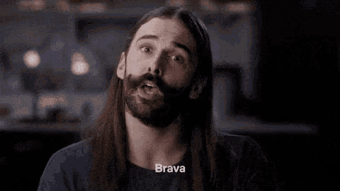 a man with long hair and a beard has the word brava on his chest