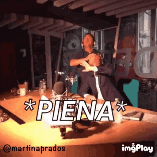 a man in a suit is sitting at a table with the word piena written on it