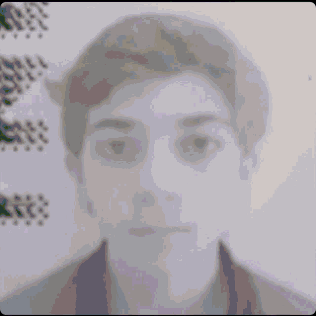 a black and white photo of a young man 's face with a blurred background