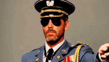 a man in a military uniform is wearing sunglasses and holding a sword .