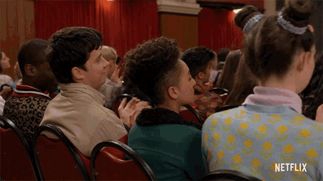 a group of people sitting in red chairs with netflix written on the bottom