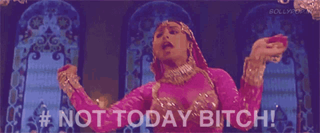 a woman in a pink dress is dancing in front of a building and says not today bitch .