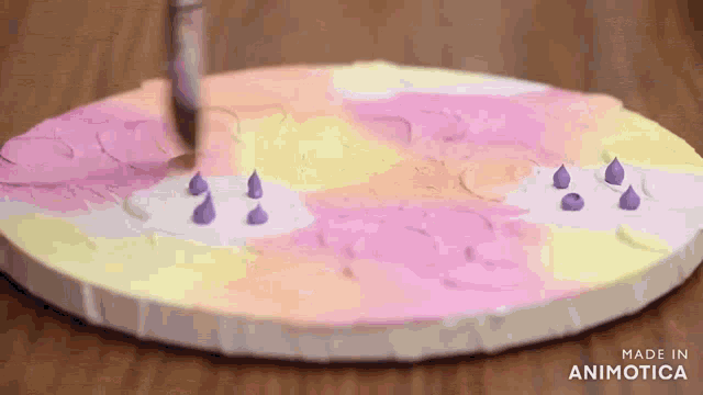 a person is painting a circle with a brush on a table .