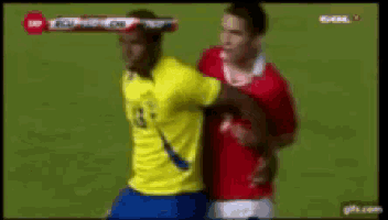 a soccer player in a yellow jersey is being tackled by a player in a red shirt