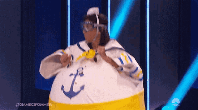 a woman in a sailor costume with an anchor on it is on a stage .