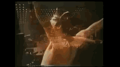 a man without a shirt is standing on a stage with his arms outstretched in the air .