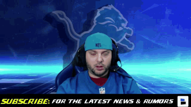 a man wearing headphones and a nfl hat is sitting in front of an nfl logo