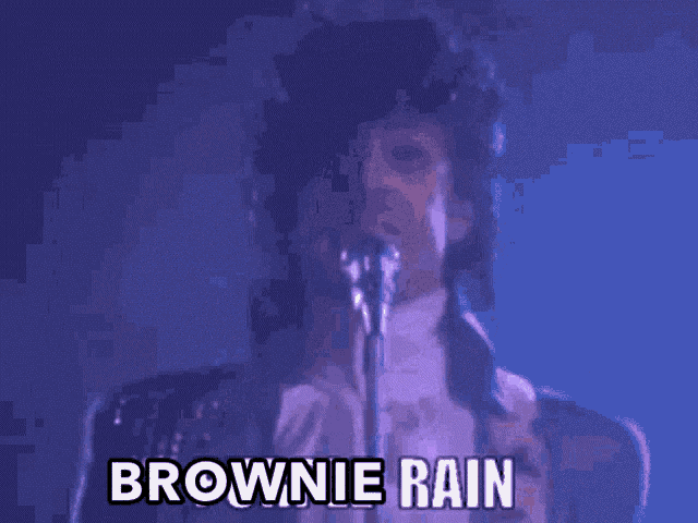a man singing into a microphone with the words brownie rain written above him