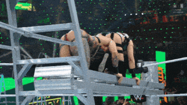 wrestlers in a wrestling ring with the letters w on the bottom left