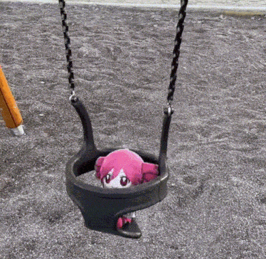 a pink stuffed animal is sitting on a swing in a playground .