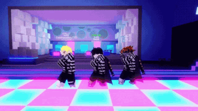 three people are dancing on a dance floor in front of a large screen