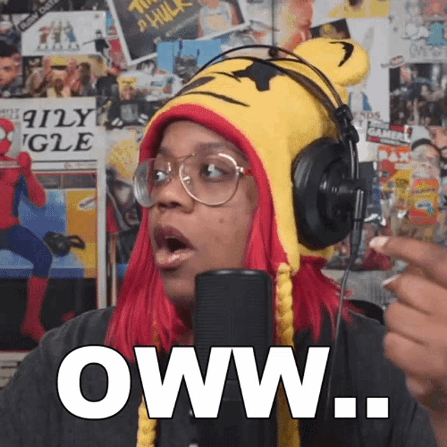 a woman wearing a tiger hat and headphones says oww in front of a microphone
