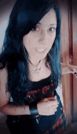 a woman with blue hair is wearing a black top that says heavy metal on it