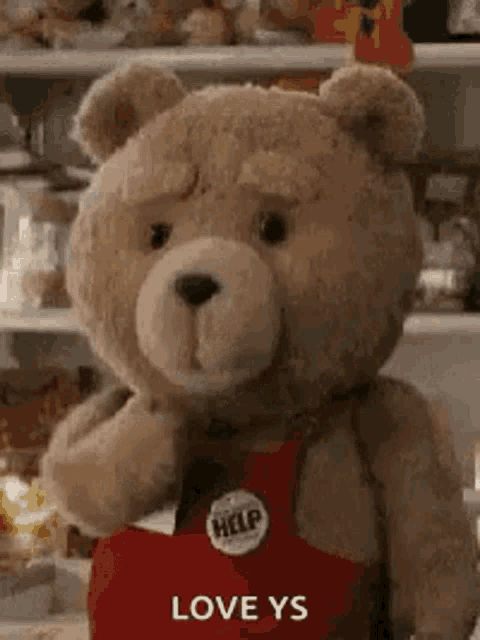 a teddy bear wearing a red apron with the words `` love ys '' written on it .
