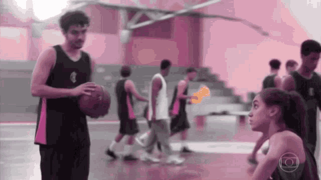 a man holding a basketball stands next to a girl on a court