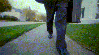 a person walking down a sidewalk with a briefcase on their back