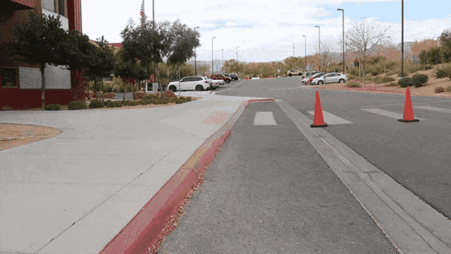 a street with a red curb and orange cones on the side