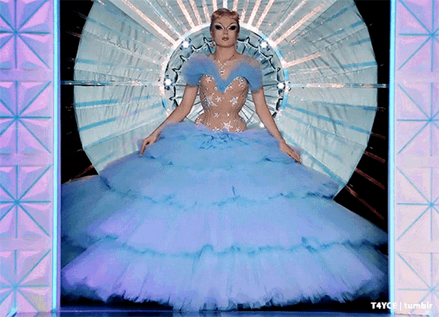 a woman in a blue ball gown is standing in front of a mirror with tumblr written on it