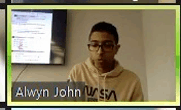 a young man wearing glasses is sitting in front of a computer monitor .
