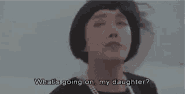 a woman is wearing a wig and pearls and asking what 's going on .