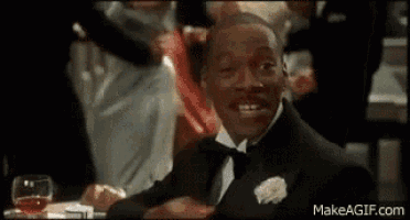 a man in a tuxedo is sitting at a table in a restaurant .